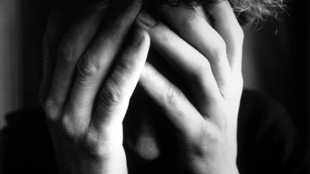 Jeune homme tenant son visage dans ses mains pour illustrer le suicide